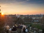 PARIS, FRANCE - MARCH 06, 2014: People enjoying the popular view of Montmartre at sunset from les Buttes Chaumont park