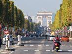 Vehicles travel along Champs Elysees - one of a famous touristic attractions in Paris.